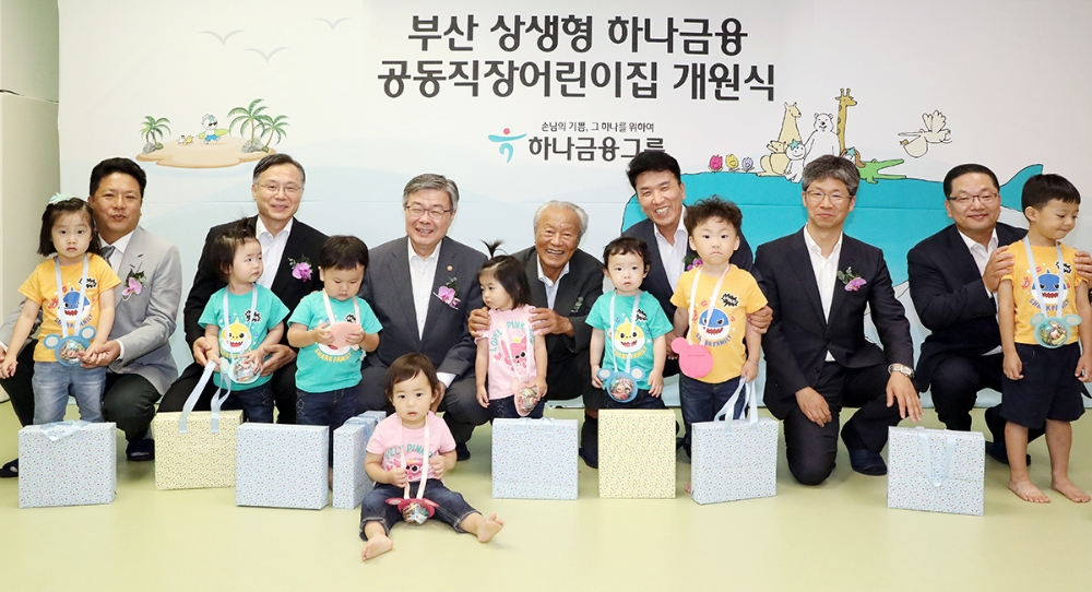 하나금융그룹은 28일 부산광역시 연제구 반송로에 위치한 KEB하나은행 연산동지점 2층에 영남지역 첫 번째 상생형 공동직장 어린이집 '부산 상생형 하나금융 공동직장 어린이집'을 개원했다. 박승 하나금융그룹 사회공헌위원회 위원장(사진 왼쪽에서 네번째)과 함영주 하나금융그룹 부회장(사진 왼쪽에서 다섯번째)이 참석 내외빈 및 어린이들과 함께 기념 세레모니를 하고 있다.(사진 왼쪽부터) 김재우 워크재활의학과병원장, 심경우 근로복지공단 이사장, 이재갑 고용노동부 장관, 박승 하나금융그룹 사회공헌위원회 위원장, 함영주 하나금융그룹 부회장, 이성문 부산광역시 연제구청장, 이호성 KEB하나은행 영남영업그룹 총괄부행장. / 사진= 하나금융지주