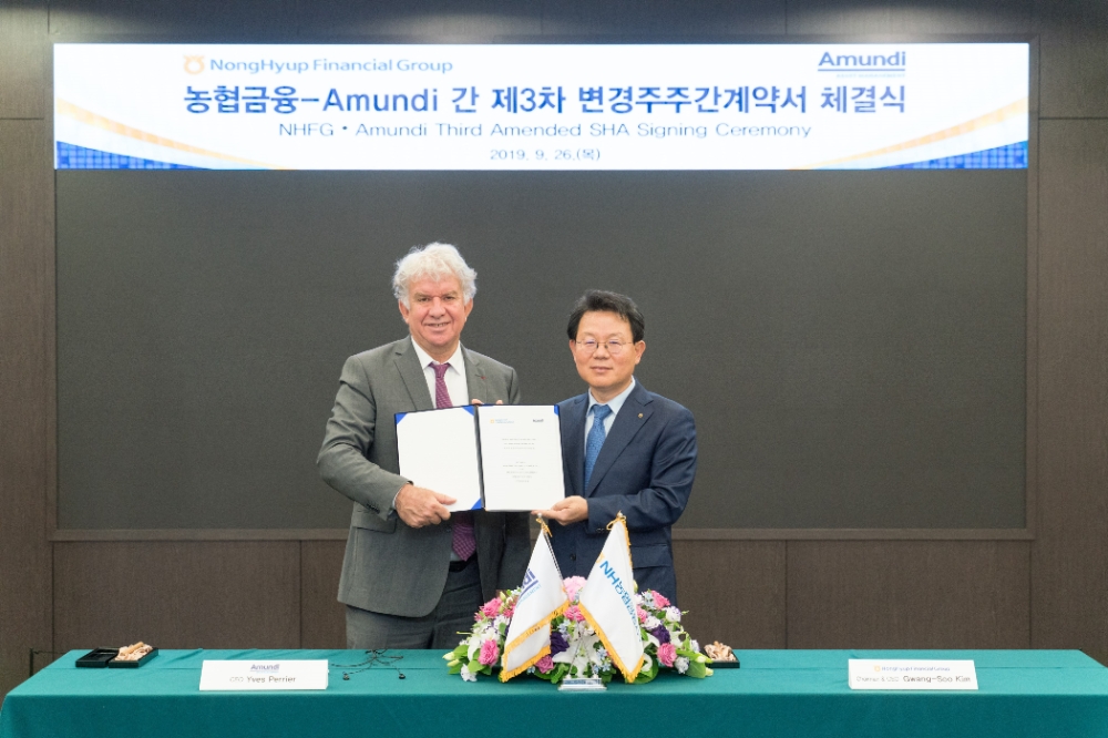 26일 서울 중구 소재 농협금융 본사에서 진행된 '농협금융-Amundi 간 제3차 변경주주간계약서 체결식'에서 김광수 농협금융 회장(오른쪽)과 이브 페리에(Yves Perrier) 프랑스 Amundi社 회장이 계약서에 서명 후 기념촬영을 하고 있다./사진=NH농협금융지주