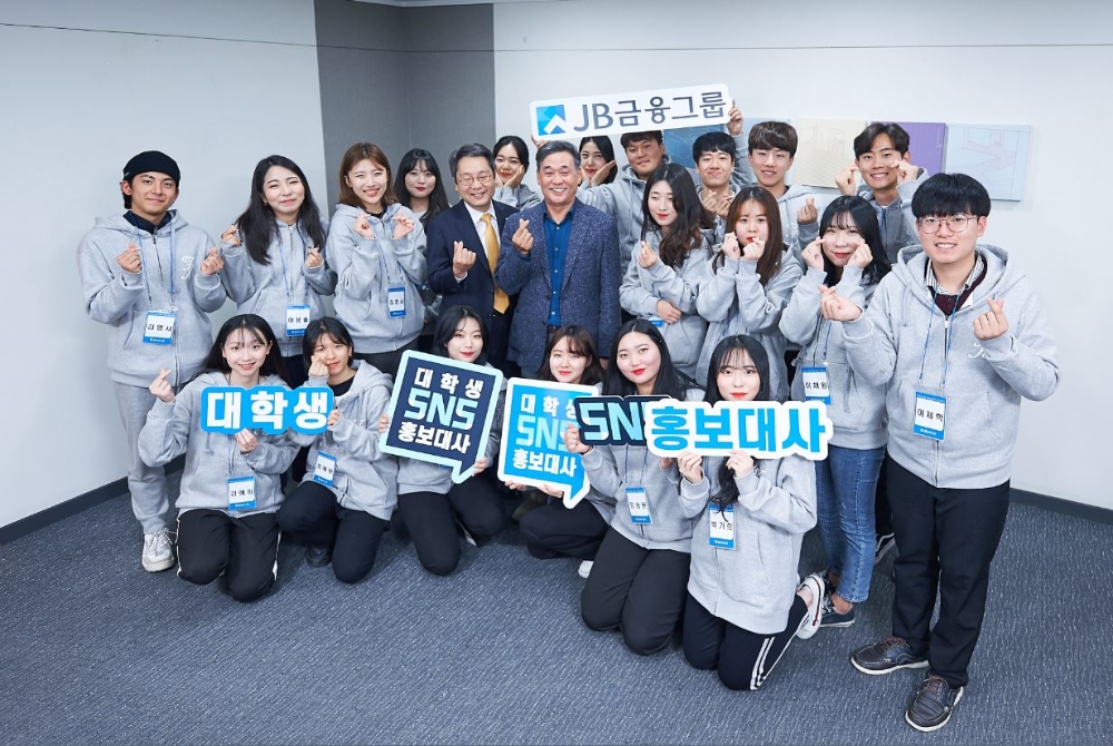 김기홍 JB금융그룹 회장(가운데)과 JB금융그룹 대학생 SNS 홍보대사들이 지난 1일 서울 여의도 사무실서 열린 ‘제1기 대학생 SNS 홍보대사’ 발대식에서 기념촬영을 하는 모습./사진=JB금융