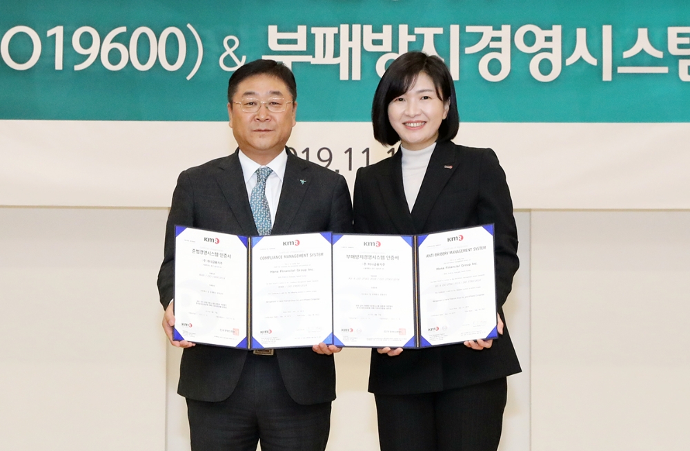 하나금융지주는 국내 금융권 최초로 준법경영시스템(ISO19600) 및 부패방지경영시스템(ISO37001)의 국제 표준 인증을 동시에 획득, 13일 오전 명동 소재 본점에서 한국경영인증원(KMR)로부터 이에 대한 국제 표준 인증서를 공식 수여받았다. 강태희 하나금융지주 준법감시인(사진 왼쪽)과 황은주 한국경영인증원(KMR) 원장이 기념촬영을 하고 있다. / 사진= 하나금융지주