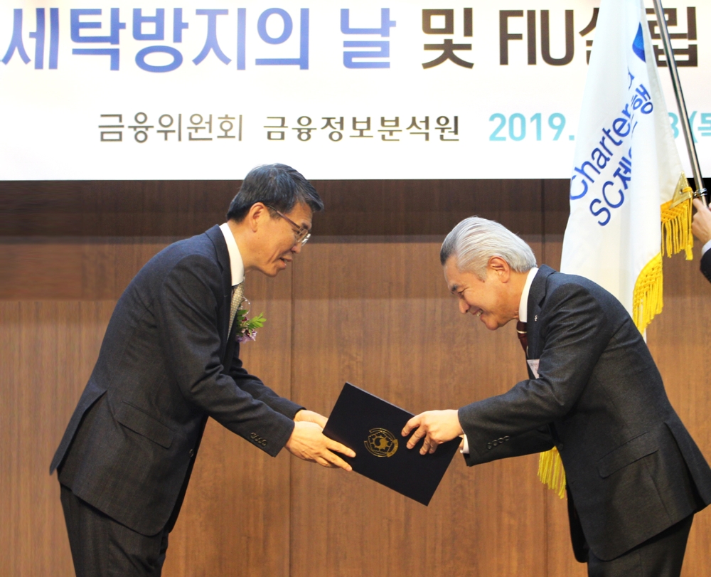 박종복 SC제일은행장(오른쪽)이 지난 28일 서울 중구 은행연합회 국제회의실에서 열린 ‘제13회 자금세탁방지의 날’ 행사에서 은성수 금융위원장(왼쪽)으로부터 대통령 표창을 받고 있다./사진=SC제일은행