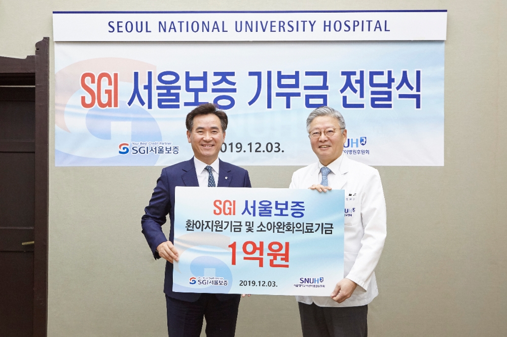 서울시 종로구 서울대학교병원 회의실에서 김상택 SGI서울보증 사장(왼쪽)이 김연수 서울대학교병원장에게 저소득 환아 치료를 위한 기부금을 전달하고 있다./ 사진=SGI서울보증