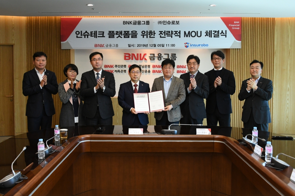 (왼쪽에서 네번째부터) 박훈기 BNK금융지주 그룹D-IT 부문장, 손성일 인슈로보대표가 협약식 후 기념촬영을 하고 있다./사진=BNK금융