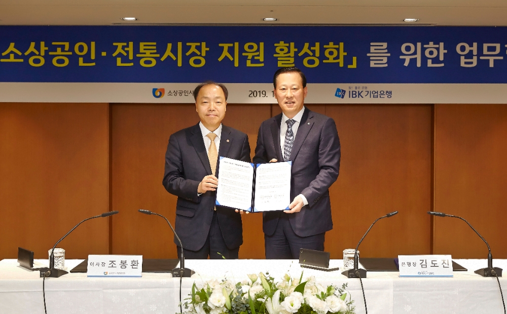 12월 13일 을지로 기업은행 본점에서 열린 ‘소상공인·전통시장 지원 활성화를 위한 업무협약식’을 마치고 김도진 IBK기업은행 은행장(오른쪽), 조봉환 소상공인시장진흥공단 이사장(왼쪽)이 기념촬영을 하고 있는 모습. / 사진= IBK기업은행