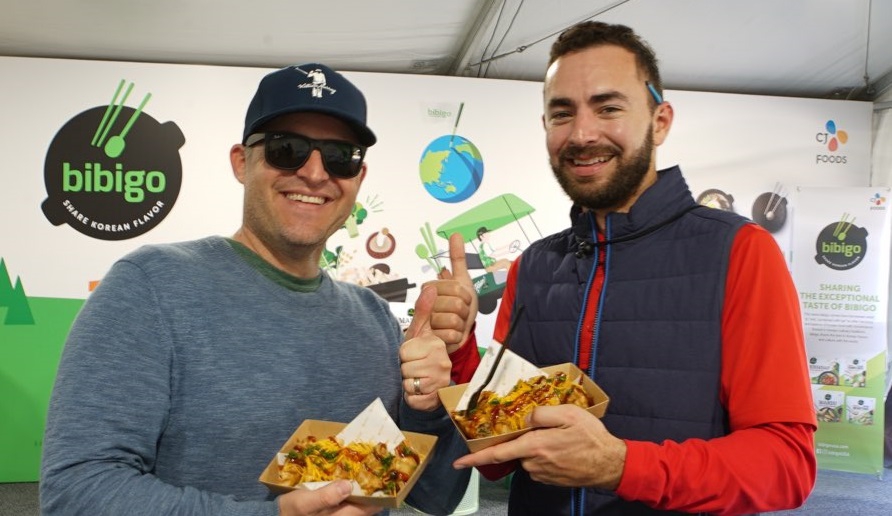 지난 13~16일(현지시간) 미국 리비에라 컨트리클럽에서 개최된 ‘제네시스 인비테이셔널(Genesis Invitational)’ 대회장 내 마련된 비비고 부스에서 갤러리들이 '비비고 왕교자'를 맛본 후 포즈를 취하고 있다. /사진제공=CJ제일제당