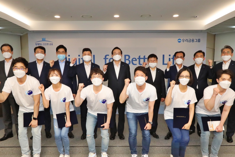 우리금융그룹은 지난 5월 15일 그룹 디지털 비전을 선포하고 '디지털혁신위원회' 출범식을 진행했다. 우리금융그룹 손태승 회장(뒷줄 왼쪽부터 다섯번째)과 권광석 우리은행장(뒷줄 왼쪽부터 네번째)이 자회사 CEO(최고경영자)로 구성된 디지털혁신위원회 위원 및 블루팀과 기념촬영을 하고 있다. (뒷줄 왼쪽부터) 이동연 우리에프아이에스 대표, 김종득 우리종합금융 대표, 정원재 우리카드 대표, 권광석 우리은행장, 손태승 우리금융그룹 회장, 이원덕 우리금융지주 전략부문 부사장, 김정기 우리금융지주 사업관리부문 부사장, 박경훈 우리금융지주 재무부문 부사장, 노진호 우리금융지주 IT/디지털부문 부사장 / 사진= 우리금융지주(2020.05.15)