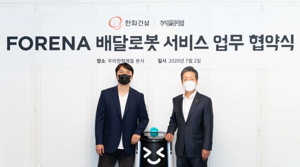 한화건설 윤용상 건축사업본부장, 배달로봇, 우아한형제들 윤현준 부사장이 ‘FORENA 배달로봇 서비스 업무협약’(MOU) 후 기념촬영을 진행하고 있다. / 사진=한화건설