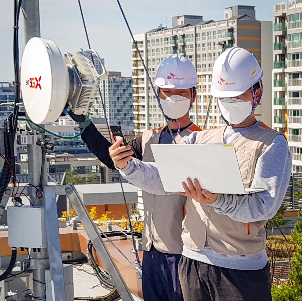 SK텔레콤이 광케이블 매설하기 어려운 지역에도 고품질 5G 서비스 제공을 강화하기 위해 5G 무선 프론트홀 장비를 도입했다고 15일 밝혔다. 사진은 SK텔레콤 엔지니어들이 5G 무선 프론트홀 장비를 구축하는 모습./사진=SK텔레콤
