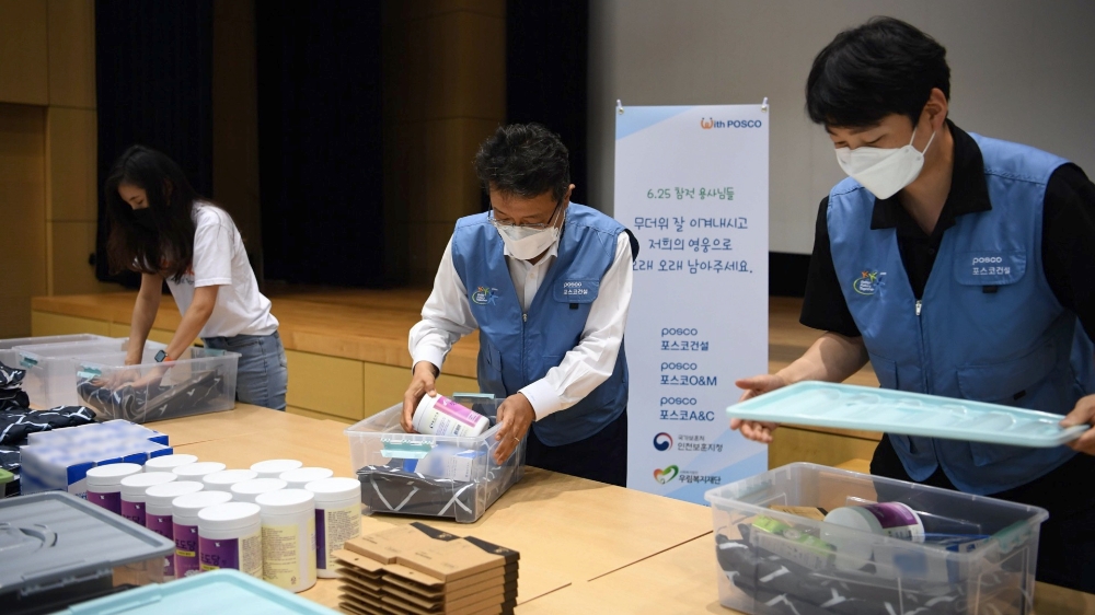 한성희 포스코건설 사장(사진 가운데)이 임직원들과 함께 6·25 참전 유공자를 위한 폭염 피해방지 키트를 제작하고 있다. / 사진=포스코건설