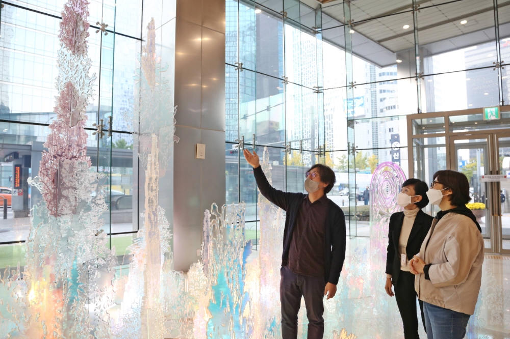 신한카드 본사 사옥 로비에 전시 중인 설치미술 작품 ‘숨의 숲’에 대하여 ‘홍범’ 작가가 설명하고 있다. /사진제공=신한카드