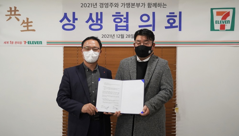(왼쪽부터) 최경호 세븐일레븐 대표와 계상혁 세븐일레븐 경영주협의회장이‘2022 가맹점 상생협약’ 체결하고 기념사진을 촬영하고 있다./사진제공=세븐일레븐