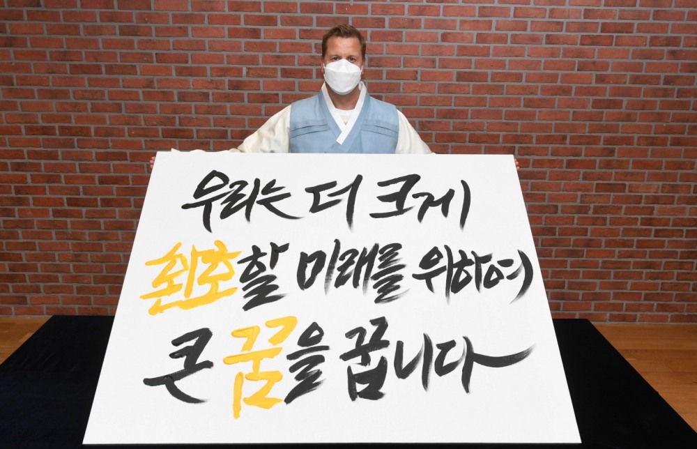 26일, 오비맥주 배하준 대표가 새로운 기업 슬로건을 공개하는 선포식에서 새 슬로건 캘리그래피 작품을 들고 기념 촬영을 하고 있다./ 사진제공 = 오비맥주
