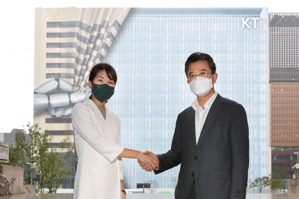 KT 전략기획실장 김채희 전무(좌)와 서울시 주용태 문화본부장(우)이 KT 광화문 West 사옥 공사 가림막을 배경으로 세종문화회관 중앙계단에서 업무협약을 체결했다. 사진=KT