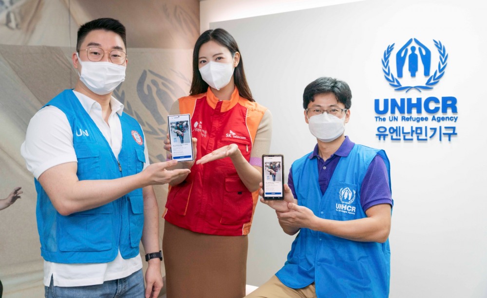 SKT와 유엔난민기구 직원들이 SKT RCS비즈웹을 통해 발송한 메시지를 소개하고 있다. 사진=SK텔레콤