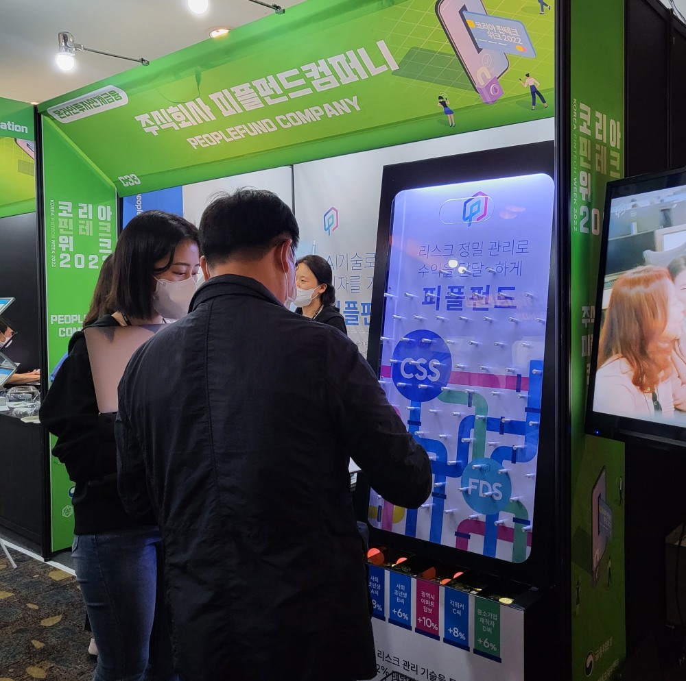 핀테크 주제관 내 피플펀드 부스에서 핀볼 게임 이벤트에 참여하고 있다.