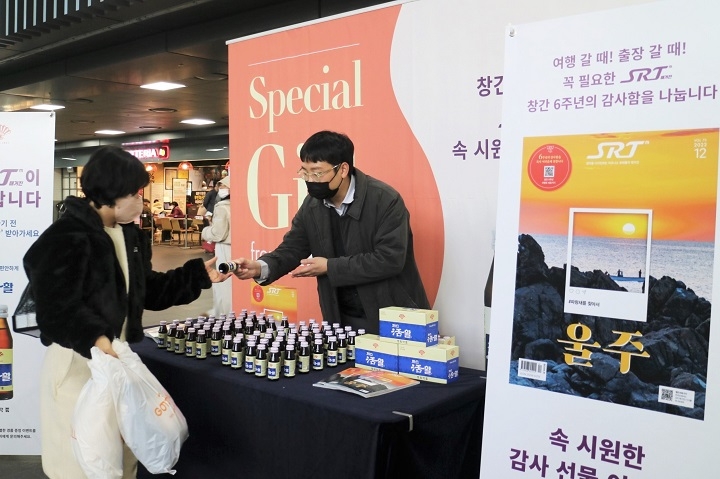 SR 관계자가 SRT 수서역에서 ‘2023년 SRT 달력’과 음료 나눔 행사를 진행하는 모습./사진제공=SR