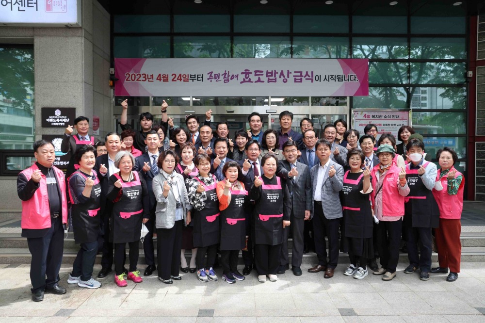 박강수 구청장(가운데)을 포함한 주요내빈과 홍보단, 봉사단이 24일 주민참여 효도밥상 서강동 1호점 앞에서 기념촬영을 하는 모습./사진제공=마포구