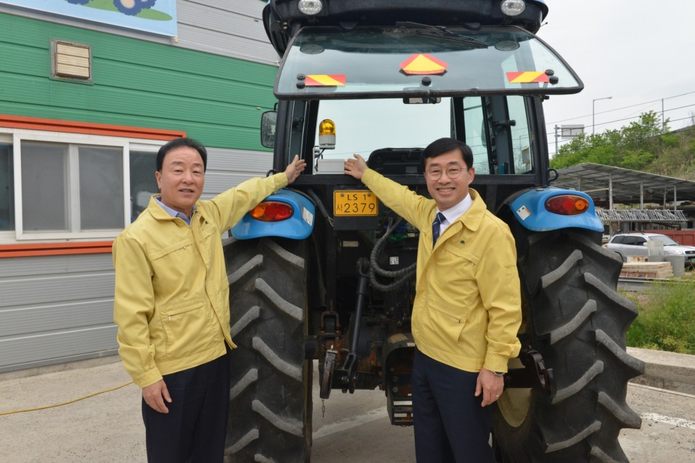 최문섭 NH농협손해보험 대표이사(왼쪽)가 윤종철 농촌진흥청 차장과 농기계 사고예방시스템 설치 후 기념촬영을 하고 있다./사진제공=NH농협손해보험