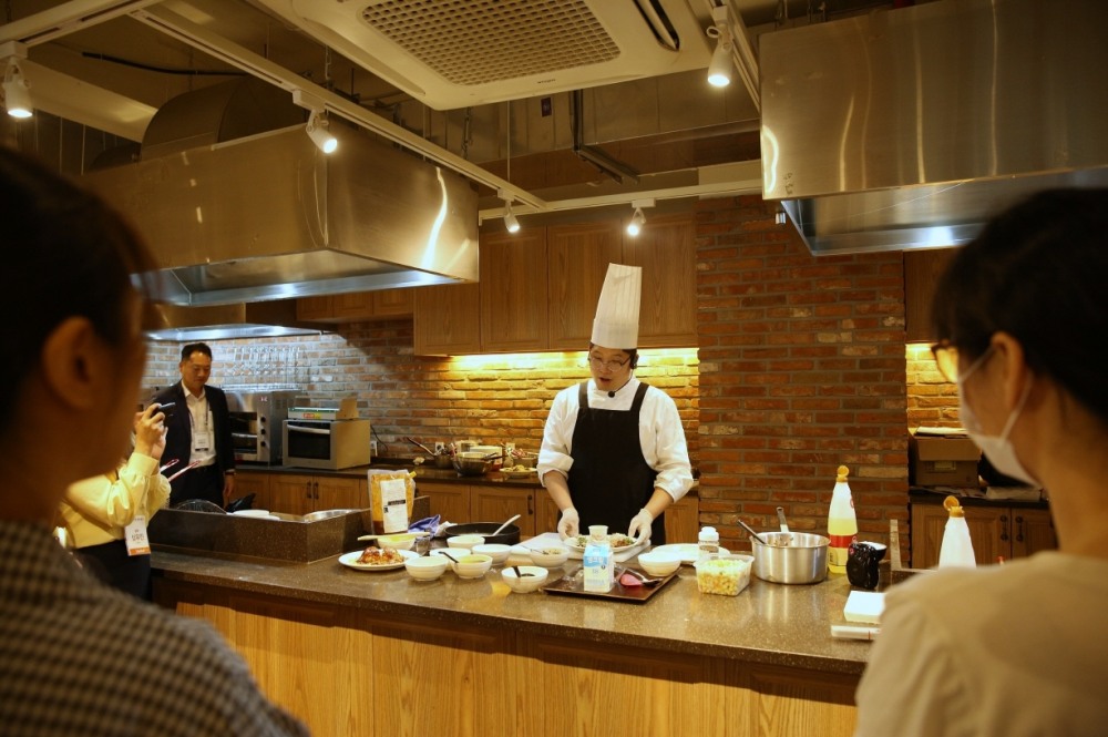 13일 아워홈 동서울물류센터 내 쿠킹스튜디오에서 진행된 ‘간소화 식재 활용 정기 메뉴시연회’에서 아워홈 셰프가 프리미엄 메뉴 조리 과정을 고객에게 설명하고 있다./ 사진 = 아워홈