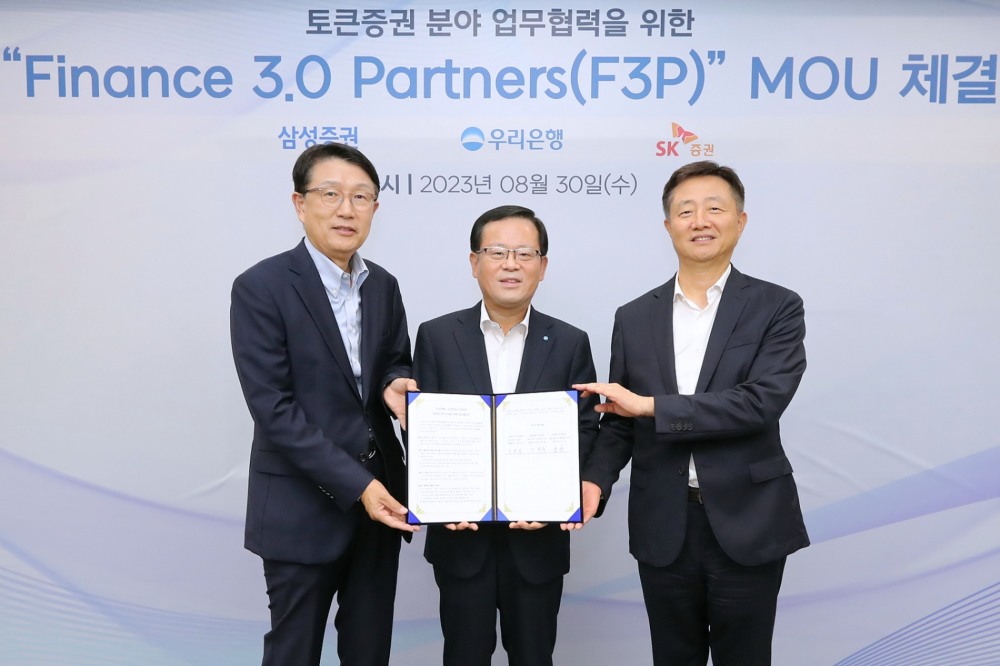 (사진 왼쪽부터) 장석훈 삼성증권 대표이사, 조병규 우리은행장, 김신 SK증권 대표이사가 지난 30일 토큰증권 분야 시장 진출을 위한 업무협약을 체결하고 기념촬영을 하고 있다./사진제공=우리은행