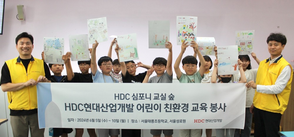 HDC현대산업개발은 지난 5일 심포니 교실 숲 조성 활동의 일환으로 서울시 노원구에 있는 태릉초등학교에서 친환경 교육 봉사를 진행하고 기념촬영을 하는 모습.사진제공=HDC현대산업개발