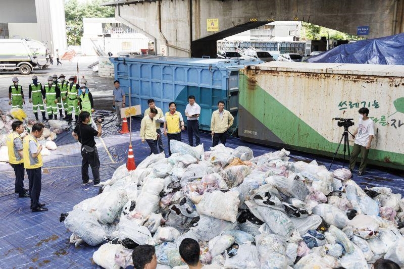 박강수 마포구청장과 관계 부서 공무원이 생활폐기물 종량제봉투 안 쓰레기를 분석하기 위해 청소 차량 차고지에 모였다./사진제공=마포구