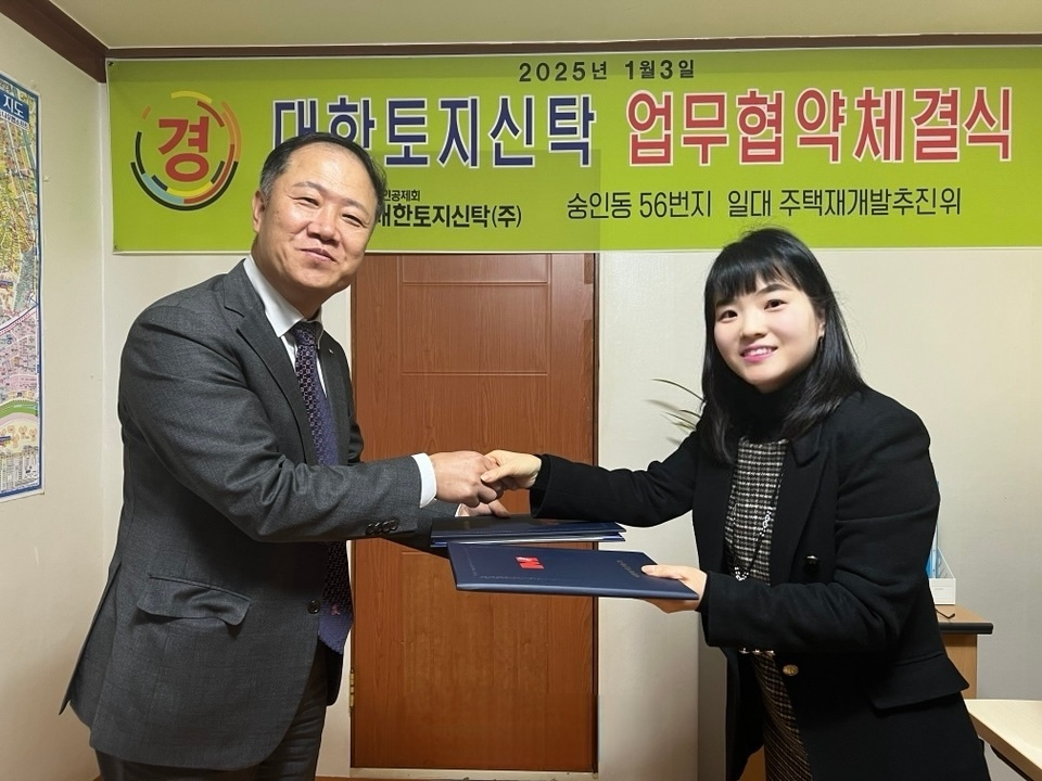 김관식 대한토지신탁 신탁사업부문이사(왼쪽)와 이미희 종로구 숭인동 56번지 일대 주택재개발추진준비위원회 위원장이 협약을 체결하고 기념촬영을 하는 모습,/사진제공=대한토지신탁