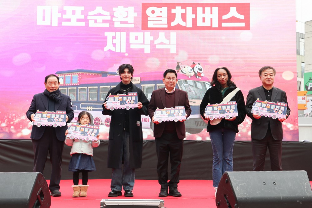 박강수 마포구청장(왼쪽에서 네번째)와 가수 정동원(세번째)이 마포순환열차버스 제막식에서 참석객들과 기념촬영을 하고 있다./사진제공=마포구