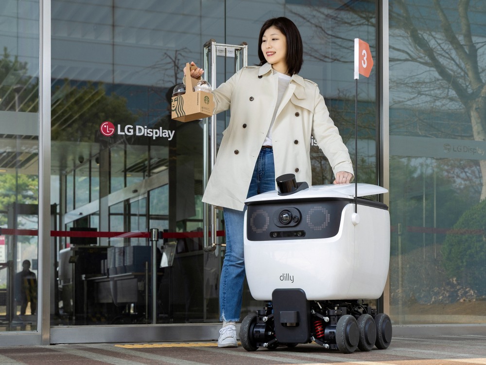 LG디스플레이 직원이 자율주행 로봇 배달 서비스를 통해 배달된 음료를 수령하고 있다. / 사진=LG디스플레이