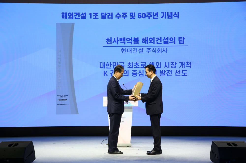 한덕수 대통령 권한대행 국무총리가 서울 강남구 건설회관에서 열린 '해외건설 1조 달러 수주 및 60주년 기념식'에서 이한우 현대건설 대표이사에게 해외건설의 탑을 수여하는 모습./사진제공=현대건설