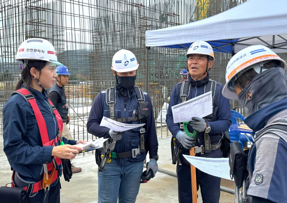 SM스틸 건설부문의 골조공사 안전관리자가 최근 경기 용인시 양지지구 공동주택 신축공사 현장에서 근로자들과 위험성평가에 따른 위험요인과 예방대책에 대해 소통하는 모습./사진제공=SM그룹