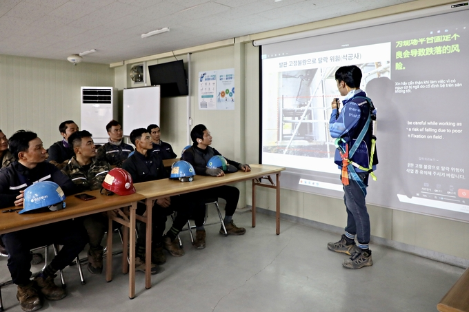 GS건설 아파트 현장에서 ‘자이 보이스’를 활용해 외국인 근로자들에게 안전교육이 진행되는 모습./사진제공=GS건설