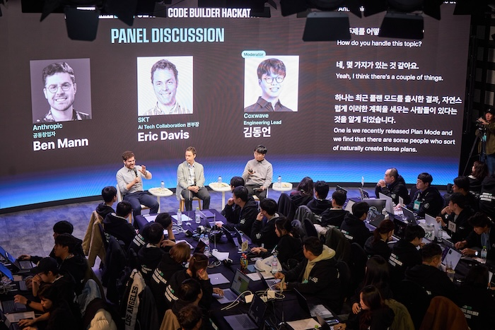 해커톤을 공동 개최한 에릭 데이비스 SKT AI 기술 협력 본부장(사진 앞줄 가운데)과 벤자민 맨 앤트로픽 공동창업자(앞줄 왼쪽), 김동언 콕스웨이브 엔지니어링 리드가 해커톤 참가자들 앞에서 AI 분야에 대한 패널 토론을 진행하는 모습. / 사진=SKT