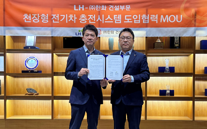 최한봉 LH 공공주택전기처장(좌측)과 박광호 한화 건설부문 건축지원실장(우측)이 차세대 천장형 전기차 충전시스템 ‘EV에어스테이션’의 시범도입을 위한 협약을 체결하고 기념촬영을 하고 있다./사진제공=한화 건설부문