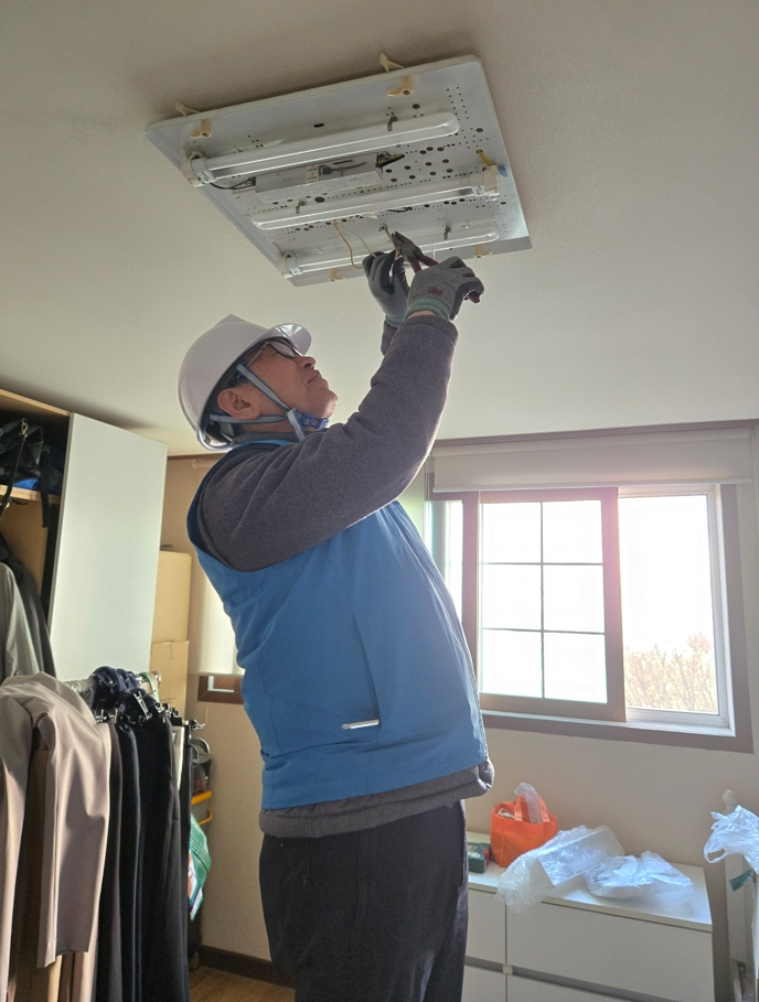 송파구 직원이 봉사활동을 통해 취약계층에 고효율 LED 조명 교체를 진행하는 모습./사진제공=송파구