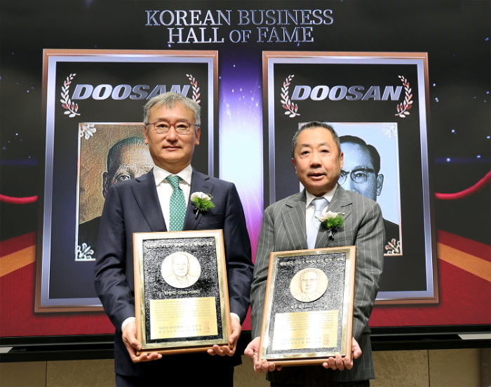 24일 서울 이화여대 경영대학 60주년 기념홀에서 열린 ‘대한민국 기업가 명예의 전당’ 헌액식에서 박정원 두산그룹 회장(오른쪽)이 헌액 기념패를 들고 양희동 한국경영학회 회장(왼쪽)과 함께 기념촬영을 하고 있다. /사진제공=두산