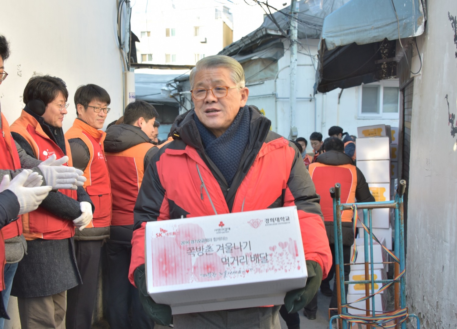 28일 동대문 쪽방촌을 찾은 최신원 SK네트웍스 회장이 생필품이 담긴 선물상자를 주민들에게 전달하고 있다.