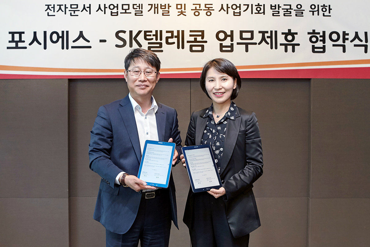 △최은식 SK텔레콤 마케팅 본부장(왼쪽)과 박미경 포시에스 대표이사(오른쪽)가 업무협약 후 기념촬영하는 모습/사진제공=SK텔레콤