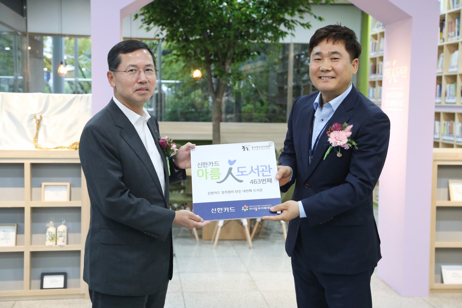△임영진 신한카드 사장(왼쪽)이 박현수 중구청소년수련관 관장에게 아름인 도서관 현판을 전달하고 있다./사진=신한카드