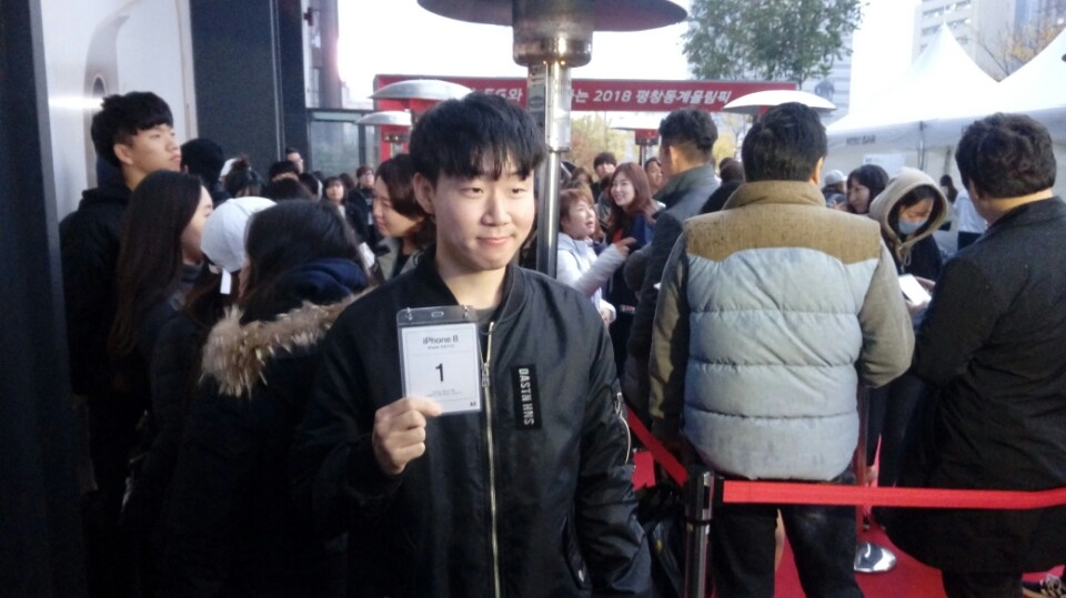 △아이폰8 개통 시작일인 3일 오전 서울 종로구 광화문 KT스퀘어에서 열린 개통행사에서 아이폰8 1호 가입자인 이규민 씨가 1번 대기표를 들고 포즈를 취하고 있다 /사진=한국