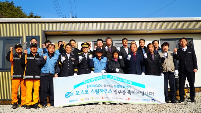 29일 경북 봉화에서 개최된 28호 스틸하우스 준공식을 기념해 포스코 자원봉사자를 비롯해 변수남 소방청 119 주조구급국장, 28호 스틸하우스 임수일 수혜자 부부, 한명구 봉화군 부군수, 김영창 봉화군의회의원, 강창훈 기아대책 본부장 등이 단체 기념촬영을 하고 있다.(왼쪽다섯번째부터).사진=포스코.