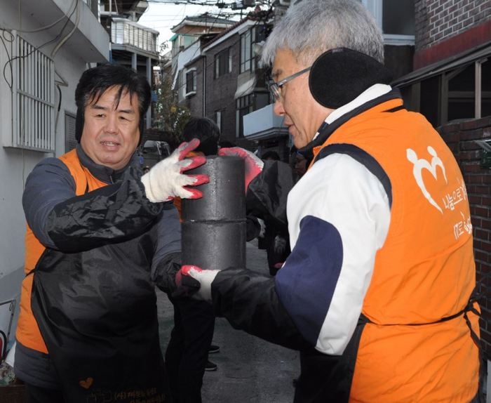 (사진 왼쪽)정지석 코스콤 사장이 지난 13일 임직원들과 지난 13일 서울 영등포구 도림동 일대에서 사랑의 연탄 나눔활동을 진행했다.