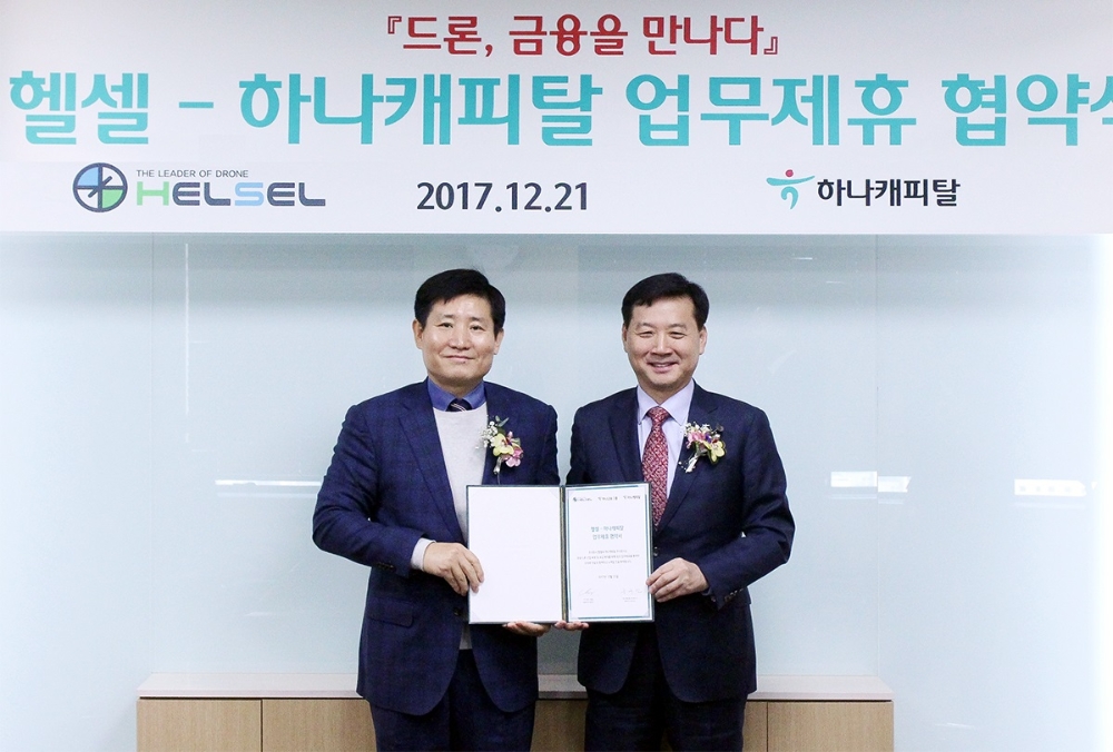 △윤규선 하나캐피탈 대표이사(오른쪽)와 장성기 헬셀 대표이사가 협약서에 서명 후 기념촬영을 하고 있다./사진=하나캐피탈