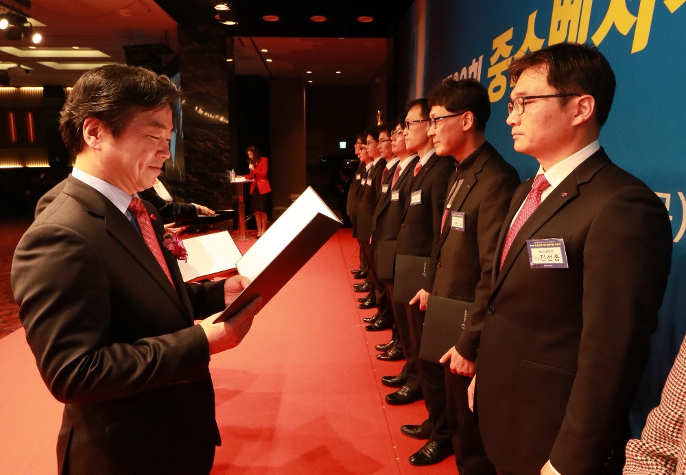 △진선종 SBI저축은행 부장(오른쪽)이 홍종학 중소벤처기업부 장관으로부터 시상을 받고 있다./사진=SBI저축은행