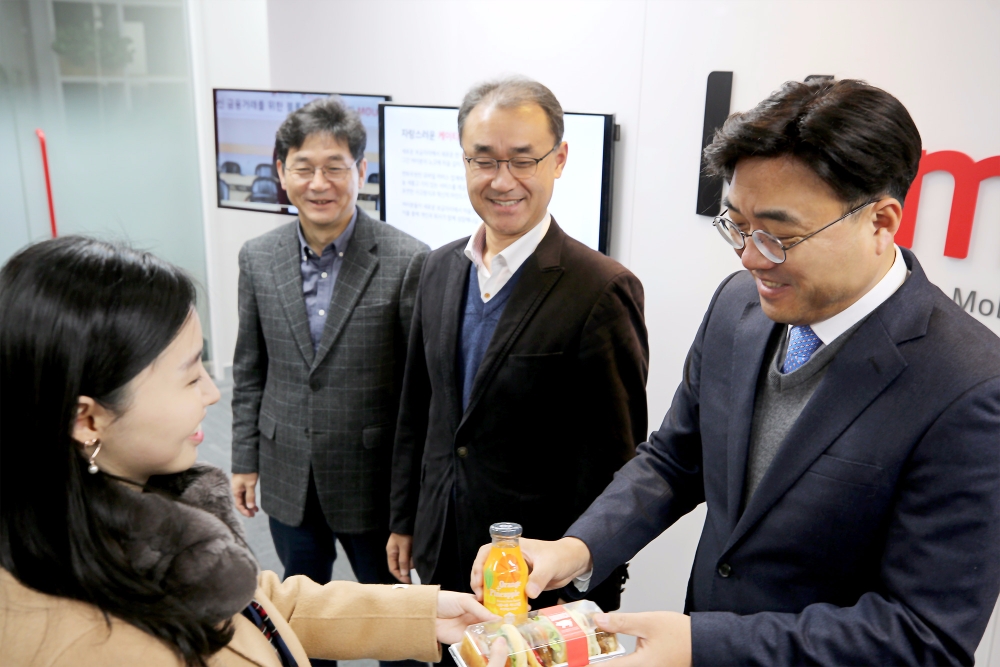 △조훈 KT 엠하우스(오른쪽 첫 번째)가 26일 신규 사옥으로 첫 출근하는 직원들을 맞이하고 있다