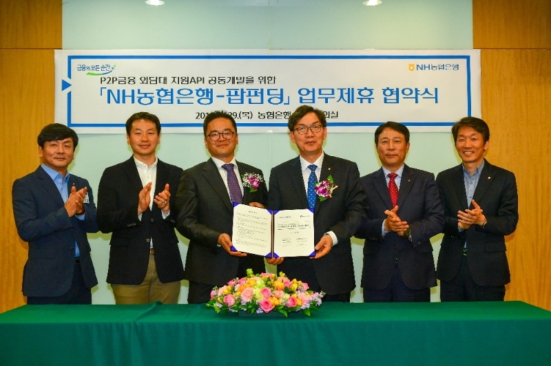 (왼쪽부터) 김봉규 NH농협은행 팀장, 김성욱 팝펀딩(주) 이사, 신현욱 팝펀딩(주) 대표이사, 이대훈 NH농협은행장, 주재승 NH농협은행 디지털전략부문 부행장, 이창기 NH농협은행 디지털전략부장이 29일 업무제휴 협약식 기념 촬영을 하고 있다. / 사진= NH농협은행