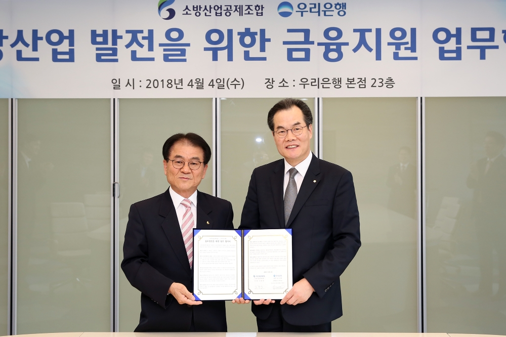 우리은행은 4일 서울 중구 본점에서 '우리은행-소방산업공제조합, 소방산업 발전을 위한 금융지원 업무협약’을 체결했다. 이동연 우리은행 중소기업그룹 부행장(사진 오른쪽)이 김철종 소방산업공제조합 이사장과 기념촬영을 하고 있다. / 사진= 우리은행