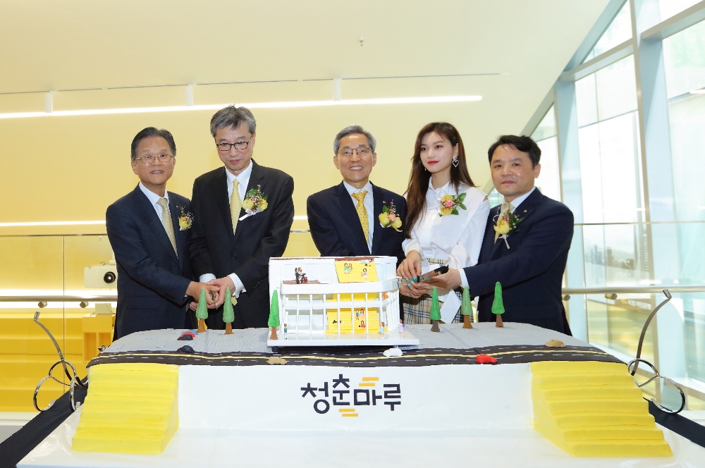 지난 27일 'KB락스타 청춘마루' 개관 기념 행사에서 (사진 왼쪽부터) 전귀상 KB국민은행 부행장, 허인 KB국민은행장, 윤종규 KB금융그룹 회장, 걸그룹 위키미키의 멤버 김도연, 오평섭 KB국민은행 부행장 등 참석자들이 청춘마루 건물 모양 초대형 축하 케이크를 자르고 있다. /사진제공=KB국민은행