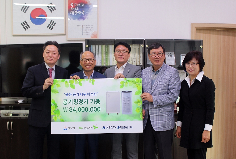 △대유위니아-성남시 공기청정기 기증식. 왼쪽부터 김재현 대유위니아 대표이사, 김병삼 월드휴먼브리지 대표, 이재철 성남시장 권한대행 부시장, 최순식 월드휴먼브리지 사무총장, 신경순 성남시 환경보건국장