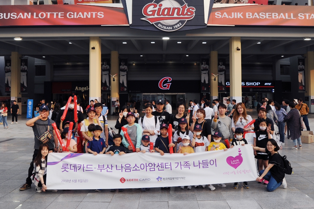 △소아암 어린이 가족과 롯데카드 임직원 봉사자, 부산 나음소아암센터 직원들이 부산 사직구장에 열리는 야구경기 관람 전에 모여 기념사진을 위해 포즈를 취하고 있다./사진=롯데카드